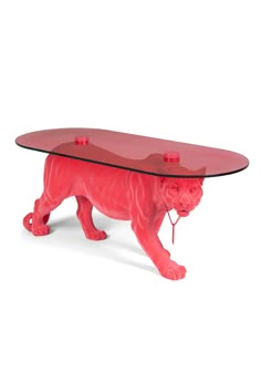 a glass table with a red cat figurine underneath it