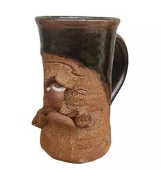 a ceramic mug with a face on it