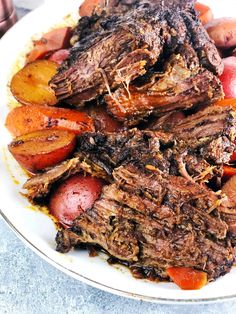 a white plate topped with meat, potatoes and carrots