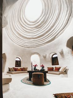 a living room filled with lots of white furniture and walls covered in circular circles on top of each other