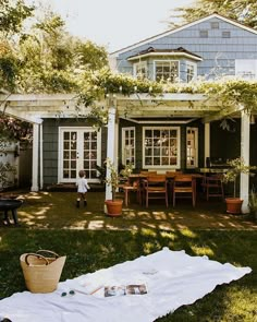 a little boy standing in front of a house next to a picnic table and chairs