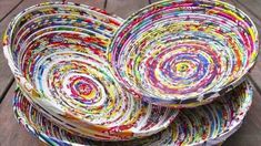 three bowls are stacked on top of each other with colorful paper in the center and bottom