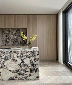 a marble counter top in a room with wood paneling and large glass doors leading to the outside