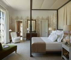 a bedroom with a four poster bed, chair and mirror on the wall next to it