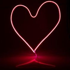 a heart - shaped object is shown in the dark with red light coming from it