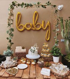 a table topped with lots of cakes and desserts next to a sign that says baby