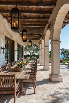 an outdoor dining area with wooden benches and lanterns