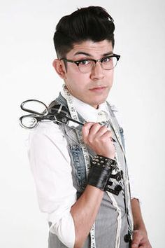 a young man wearing glasses and holding some scissors in his hand while standing against a white background