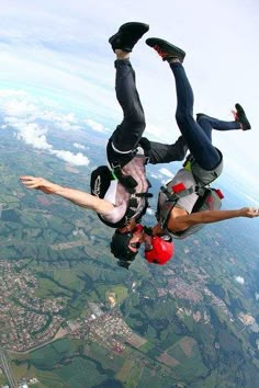 two people are skydiving in the air with their feet up and one person is upside down