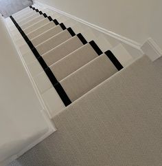 the stairs are lined with black and white carpeted treads in an empty room