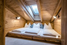 a bed in a room with wooden walls and ceiling lights on either side of it