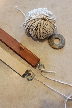 a ball of yarn and a pair of scissors on the ground next to some string