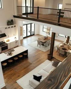 an overhead view of a living room and kitchen area with hardwood floors, white furniture, and open floor plan