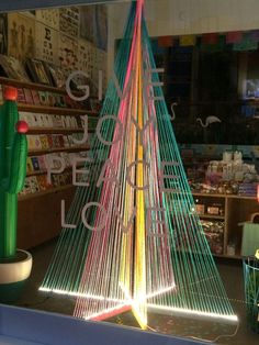 a lighted christmas tree in front of a store window