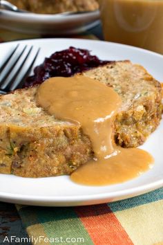 meatloaf with gravy and cranberry sauce on a white plate