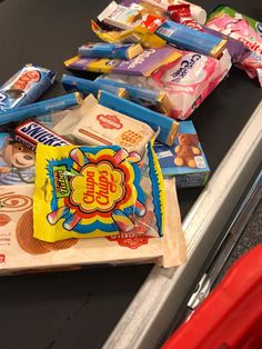 snacks are lined up on the counter in a grocery store, including candy bars and chips