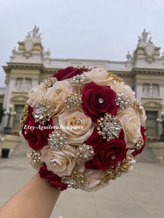 the bridal bouquet is being held by someone's hand in front of a building