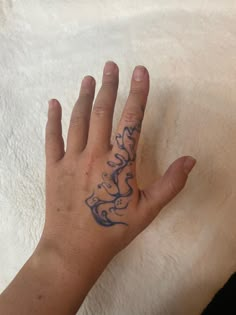 a person's hand with a tattoo on the middle of their left arm and fingers