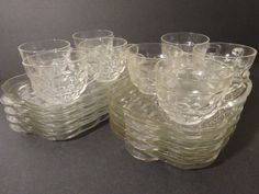 a stack of glass dishes sitting on top of a table next to another set of glasses