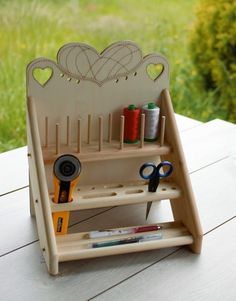 a wooden craft stand with scissors and thread