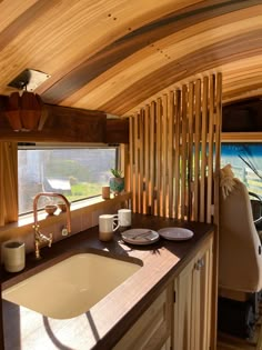 a kitchen area with sink, counter and wooden walls in an airstream that looks like a boat