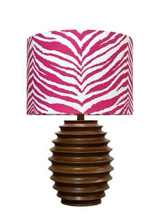 a pink and white zebra print lampshade on a wooden base with a light shade