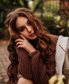 a beautiful young woman sitting on the ground