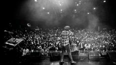 a man standing on top of a stage in front of a large group of people