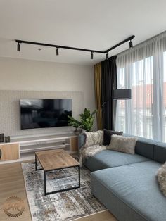 a living room filled with furniture and a flat screen tv mounted to the side of a wall