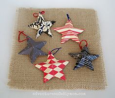 six ornaments are arranged on a burlap mat with red, white and blue designs