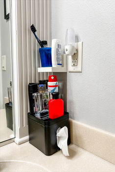 there is a toothbrush holder on top of the bathroom sink shelf next to the mirror