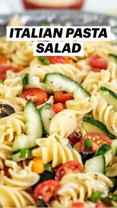 a pasta salad with zucchini, tomatoes, cucumbers and other veggies