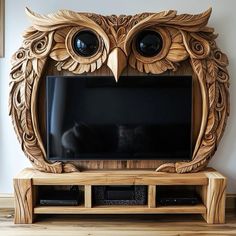 an owl shaped wooden tv stand with two large eyes on it's front and back