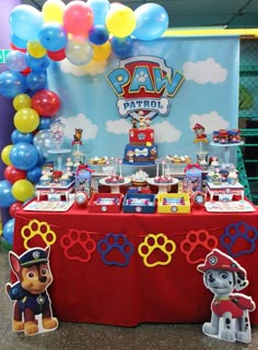 a paw patrol themed birthday party with balloons and decorations on the table for guests to eat