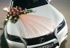 a white car with flowers on the hood