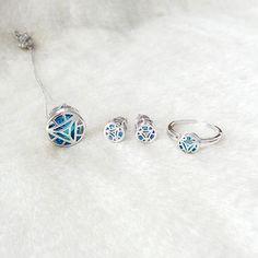 three pieces of jewelry sitting on top of a white fur covered floor next to each other