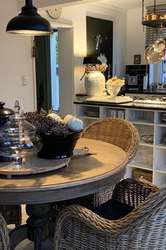 a dining room table with wicker chairs around it