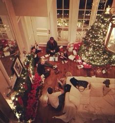 people sitting on the floor in front of christmas trees