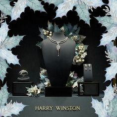 a display case with jewelry on it in front of a blue and white wallpaper