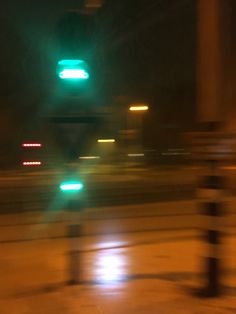 blurry image of traffic lights on the street at night with no one in sight