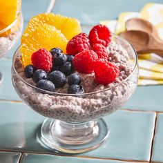 a bowl of oatmeal with berries and oranges