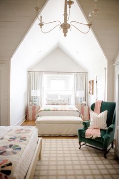 a bedroom with two beds and a green chair in the middle of the room,