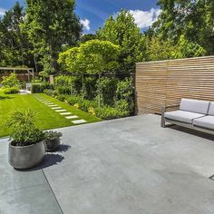 an outdoor living area with couches and landscaping