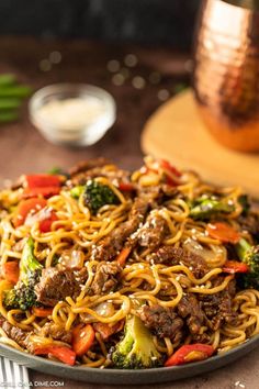 a plate full of noodles with beef and broccoli