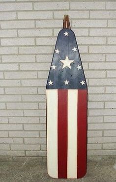 an american flag surfboard leaning against a brick wall