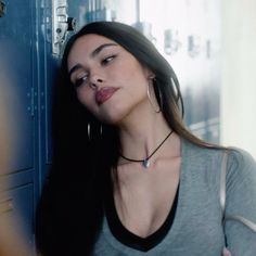 a woman standing next to a locker with her head resting on the door knobs