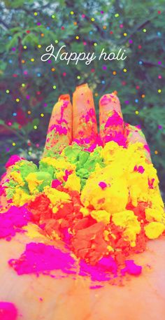 the hand is full of colorful powder and confetti