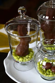 three glass containers filled with chocolate candies and candy bunny rabbits on top of them