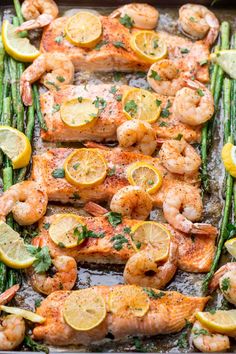 shrimp and asparagus on a sheet pan with lemons