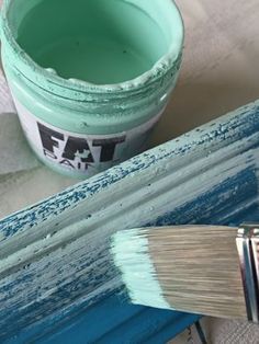 a paint can with a brush next to it